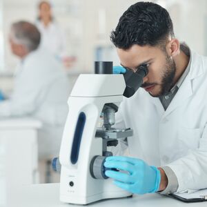 Man, scientist and microscope for research in lab with disease experiment, medical study and dna process. Researcher, biotechnology and molecule exam with engineering, vaccine and healthcare solution.