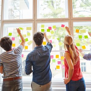 Junge Studenten im Seminar für Brainstorming mit bunten Zetteln