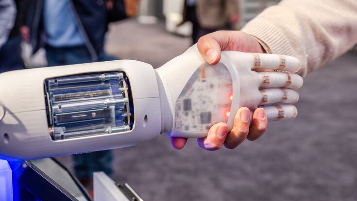 © Lukassek - stock.adobe.com Greifarm von Roboter oder Cobot schüttelt Hände mit Mensch