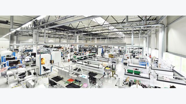 produzierender Betrieb mit Fließbändern in großer Fabrikshalle