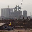 A photo taken on August 19, 2012 shows workers before a refinery near a 'toxic lake' near the inner Mongolian city of Baotou. On the edge of the Chinese city of Baotou, a 10-square-kilometre lake is blackened by pollution from factories processing rare earths, elements essential for the production of mobile phones and computers. China produces more than 95 percent of the world's rare earths, 17 elements crucial for making a range of hi-tech products. Two-thirds of that is processed in mineral-rich Baotou on the edge of the Gobi desert. AFP PHOTO / Ed Jones (Photo by Ed Jones / AFP)