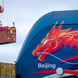 Download von www.picturedesk.com am 19.04.2022 (14:51). dpatop - 11 February 2022, Mecklenburg-Western Pomerania, Mukran: A container is unloaded behind a locomotive with an Asian dragon head and the lettering "Beijing" after the arrival of the first ship of a new "Silk Road" connection between China and Germany at the port of Mukran. The containers from Wuhan in China cover part of the route by water and are reloaded onto rail cars on the island of R?gen. Photo: Jens B?ttner/dpa-Zentralbild/dpa - 20220211_PD12844 - Rechteinfo: Rights Managed (RM)