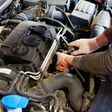 Ein Mechaniker arbeitet an einem Verbrennungsmotor. Der Verbrenner ist ab 2035 bei Pkw nicht mehr erlaubt.