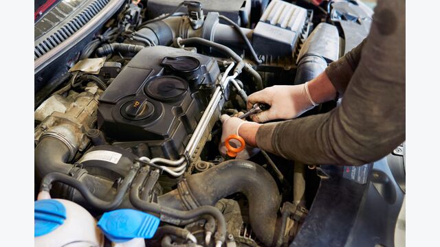 Ein Mechaniker arbeitet an einem Verbrennungsmotor. Der Verbrenner ist ab 2035 bei Pkw nicht mehr erlaubt.