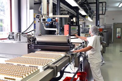 © industrieblick - stock.adobe.com Arbeiterin am Fliessband in der Lebensmittelindustrie
