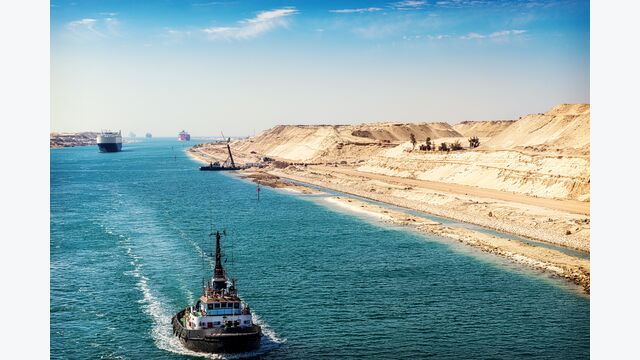 Der Suezkanal - eine Schiffskolonne durchfährt den neuen, östlichen Erweiterungskanal, eröffnet im August 2015, im Vordergrund ein Schlepper