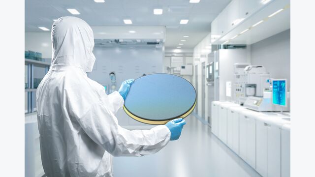 Ein Mitarbeiter in einem Schutzanzug bei der Forschungsarbeit im Labor.