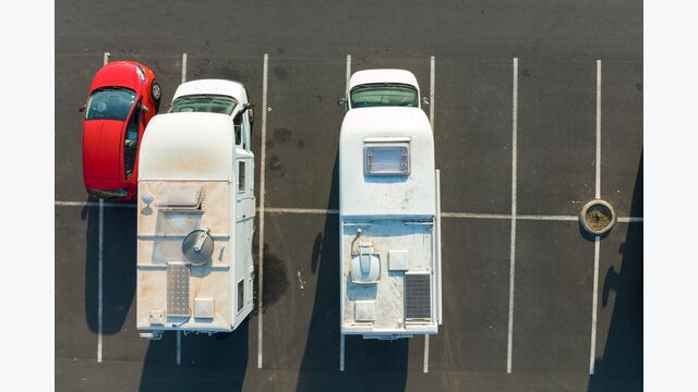 Aerial view of camper vans parked on parking lot.