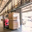 Paletten werden im Lagerhaus per Gabelstapler befördert.