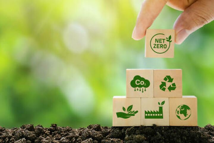 Net Zero and Carbon Neutral Concepts Net Zero Emissions Goals A climate-neutral long-term strategy Ready to put wooden blocks by hand with green net center icon and green icon on gray background.