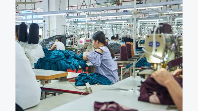 Employee's working with their sewing machines in clothing factory