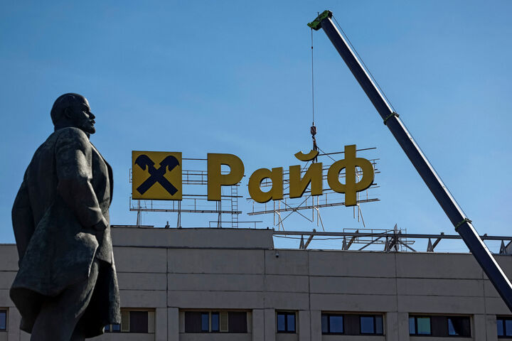Russland Raiffeisen Workers use a crane to dismantle a signboard advertising Raiffeisen Bank from a building, as a monument to Soviet state founder Vladimir Lenin is seen in the foreground, in Moscow, Russia April 14, 2023. REUTERS/Maxim Shemetov - 20230414_PD5497 - Rechteinfo: Rights Managed (RM) Nur für redaktionelle Nutzung! Werbliche Nutzung erfordert Freigabe: bitte schicken Sie uns eine Anfrage.
