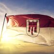 Vorarlberg state of Austria flag textile cloth fabric waving on the top sunrise mist fog