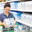 Asian woman buys in the supermarket bottle of water