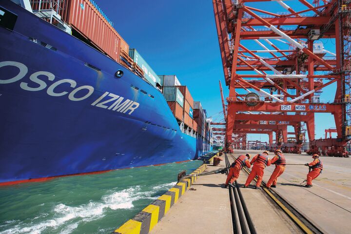 Blaues Frachtschiff an Anlagestelle in chinesischem Hafen