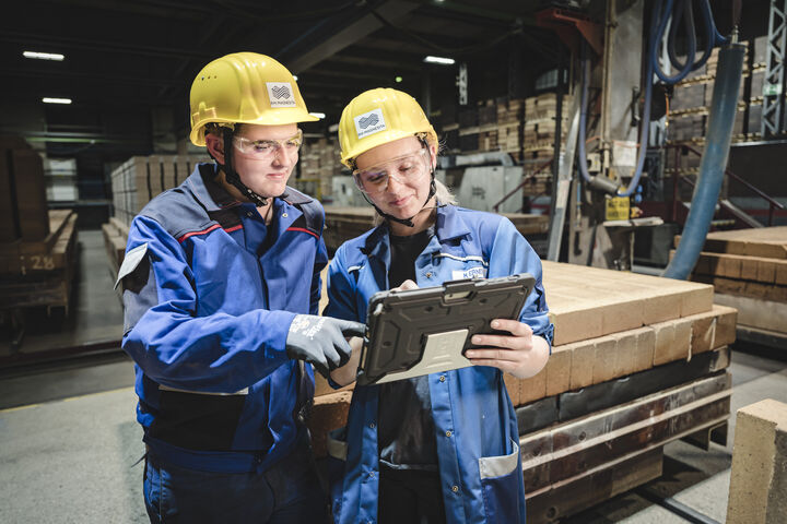 Zwei Techniker in Lagerhalle mit gemeinsamen Tablet
