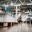Low angle view of piles of sheets in printing shop. In background are worker and printing machines.