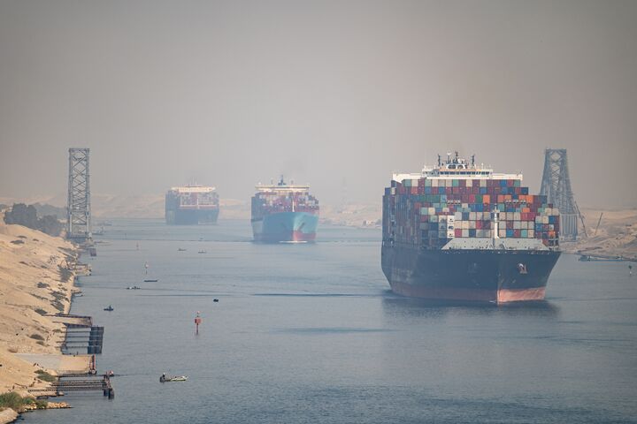 Many cargo ships navigate through Suez Canal. Shipping canal in Egypt. Concept of transportation and logistics.