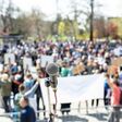 Protest or public demonstration, focus on microphone, blurred group of people in the background