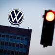 Download von www.picturedesk.com am 18.09.2024 (12:10). 04 September 2024, Lower Saxony, Wolfsburg: The VW logo shines on the roof of the brand tower at Volkswagen's main plant in the early morning behind a red traffic light. Volkswagen has announced that it will tighten its austerity measures due to the tense situation of the core brand. Even compulsory redundancies and plant closures can no longer be ruled out. Photo: Moritz Frankenberg/dpa - 20240904_PD0922 - Rechteinfo: Rights Managed (RM)