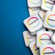 Logos of the German producer of polyurethane and polycarbonate Covestro on a heap on a table. Copy space. Web banner format.