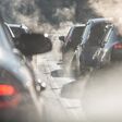 Blurred silhouettes of cars surrounded by steam from the exhaust pipes. Traffic jam