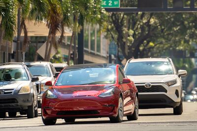 © bilanol - stock.adobe.com Tesla electric vehicle driving at intersection on American street with traffic lights in Miami, Florida. USA transportation. Miami, USA - March 1, 2023.
