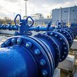 Large blue water pipes are supplying a modern water treatment plant