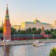 View of Kremlin with Vodovzvodnaya tower, Grand Kremlin Palace from Bolshoy Kamenny Bridge in Moscow on sunny summer day. View of Cruise ship on Moscow river from Greater Stone Bridge, Moscow, Russia
