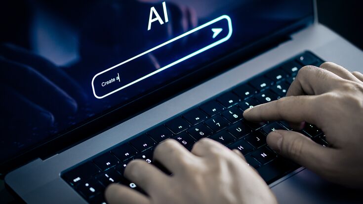 © terovesalainen - stock.adobe.com AI prompt to generate content or text with laptop and artificial intelligence. Using image generator at work. Chatbot or virtual search robot in computer. Large language model, LLM. Hands typing.