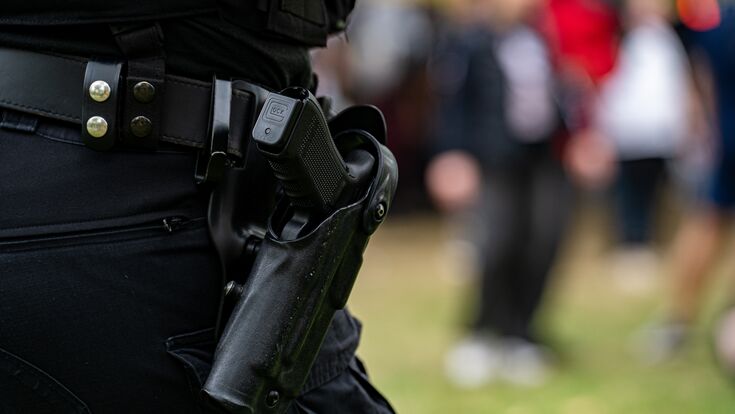 © Erman Gunes - stock.adobe.com Close up of police handgun in holster on duty belt.