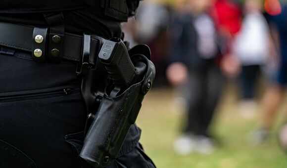 Close up of police handgun in holster on duty belt.