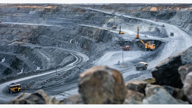 Work of heavy equipment in an open pit for gold ore mining, soft focus