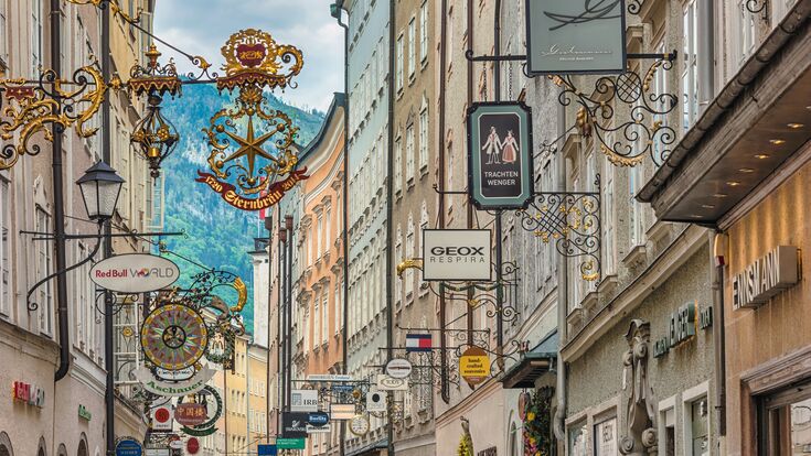 Salzburg, Austria - May 19,2019 : city skyline and wrought iron signs at Grain Lane street the famous shopping street of Salzburg Austria