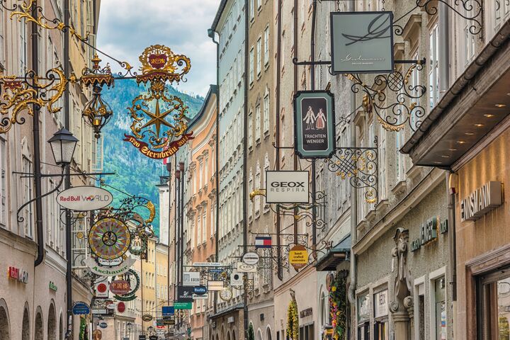 Salzburg, Austria - May 19,2019 : city skyline and wrought iron signs at Grain Lane street the famous shopping street of Salzburg Austria