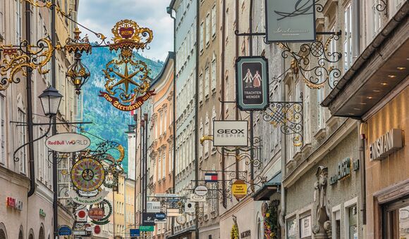 Salzburg, Austria - May 19,2019 : city skyline and wrought iron signs at Grain Lane street the famous shopping street of Salzburg Austria