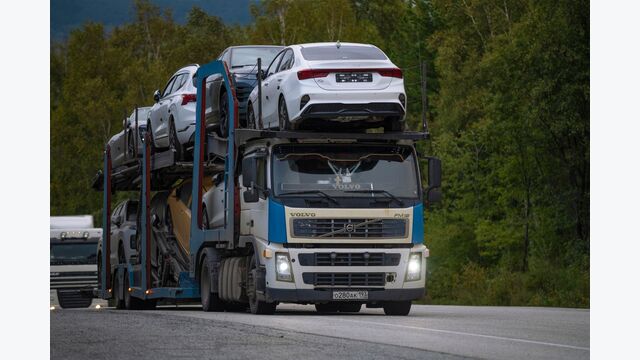 BURYATIA, RUSSIA - SEPTEMBER 06, 2025: A car transporter with passenger cars on the highway on a cloudy September day