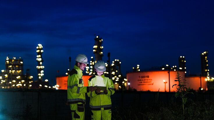 Energy professionals ensure continuous 24/7 operations at a refinery. The team uses digital technology to monitor sustainable production during the night shift.