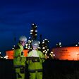 Energy professionals ensure continuous 24/7 operations at a refinery. The team uses digital technology to monitor sustainable production during the night shift.