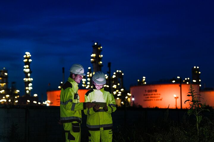 Energy professionals ensure continuous 24/7 operations at a refinery. The team uses digital technology to monitor sustainable production during the night shift.