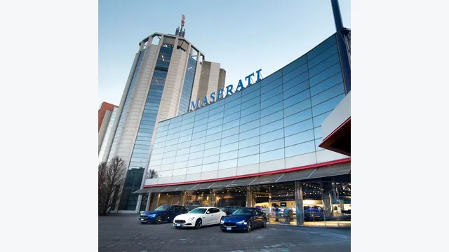 Blick auf das Maserati Werk ein Modena mit drei Maserati vor dem Gebäude