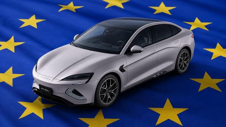 Silberner BYD Seal auf einer blauen EU-Fahne mit gelben Sternen, aus erhöhter Perspektive dargestellt.