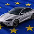 Silberner BYD Seal auf einer blauen EU-Fahne mit gelben Sternen, aus erhöhter Perspektive dargestellt.