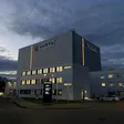 Varta-Werk mit beleuchtetem Logo bei dunklem Himmel