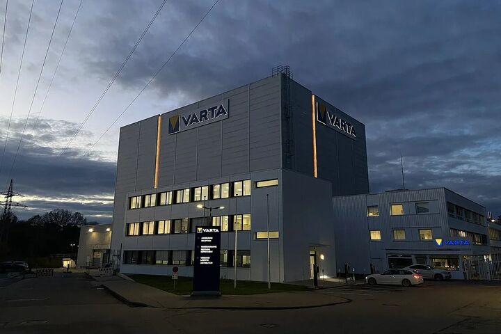 Varta-Werk mit beleuchtetem Logo bei dunklem Himmel