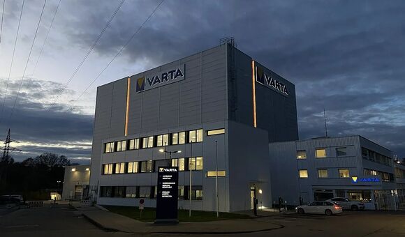 Varta-Werk mit beleuchtetem Logo bei dunklem Himmel
