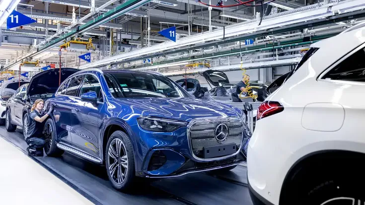 Produktion des Mercedes GLC im Werk Bremen: Ein Fahrzeug steht auf der Montagelinie, während Mitarbeitende am Elektro-SUV arbeiten.