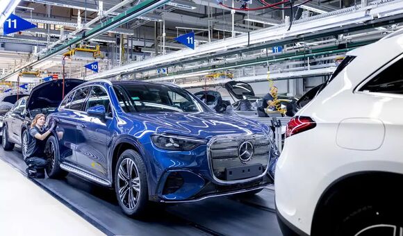 Produktion des Mercedes GLC im Werk Bremen: Ein Fahrzeug steht auf der Montagelinie, während Mitarbeitende am Elektro-SUV arbeiten.