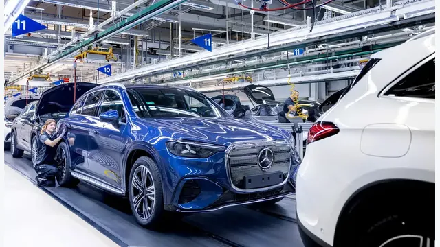 Produktion des Mercedes GLC im Werk Bremen: Ein Fahrzeug steht auf der Montagelinie, während Mitarbeitende am Elektro-SUV arbeiten.