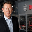 Bosch-Manager vor Produktion und Bosch-Logo: Der Konzern steht vor Umbau, Stellenabbau und hohen Investitionen